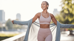 confident woman enjoying summer in tulsa, ok – standing in a sunlit park or downtown setting, wearing stylish activewear or summer dress, smiling with arms open, radiant skin glowing, soft golden-hour lighting, diverse body-positive vibe, background with subtle tulsa skyline or nature, emphasis on self-love and empowerment"