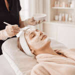 Esthetician applying facial mask during spa treatment