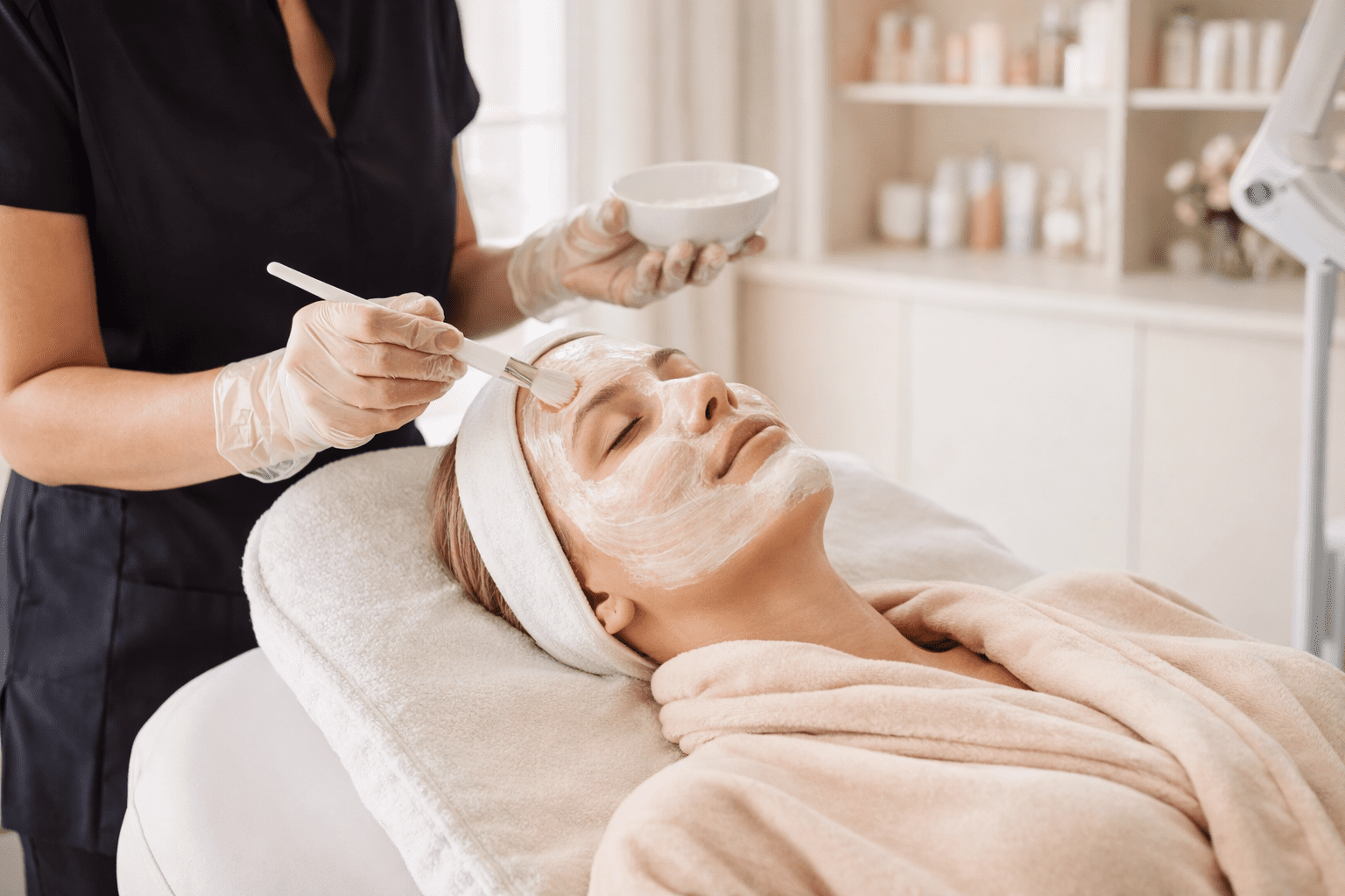 esthetician applying facial mask during spa treatment