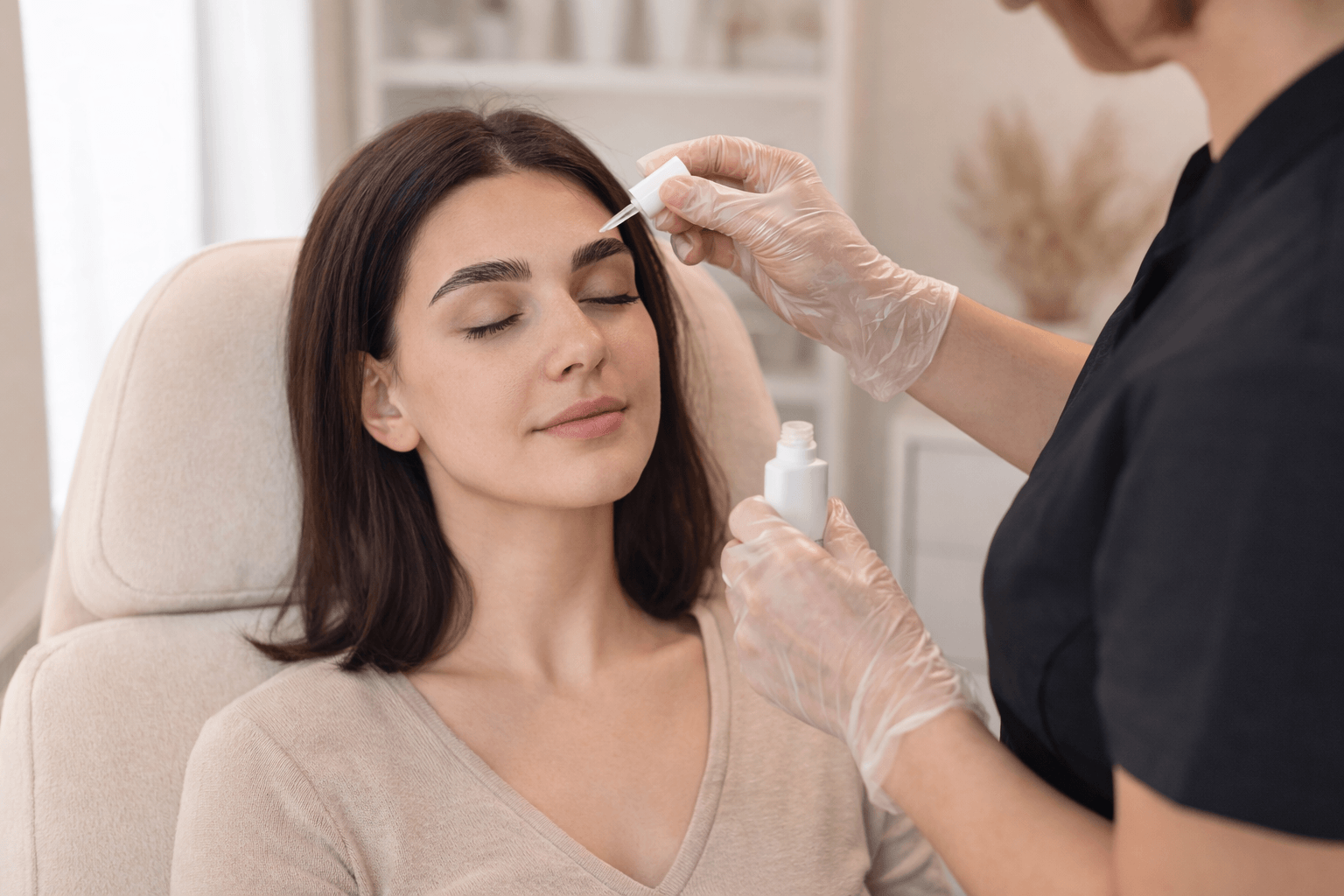 aesthetician applying skincare serum to a woman's face